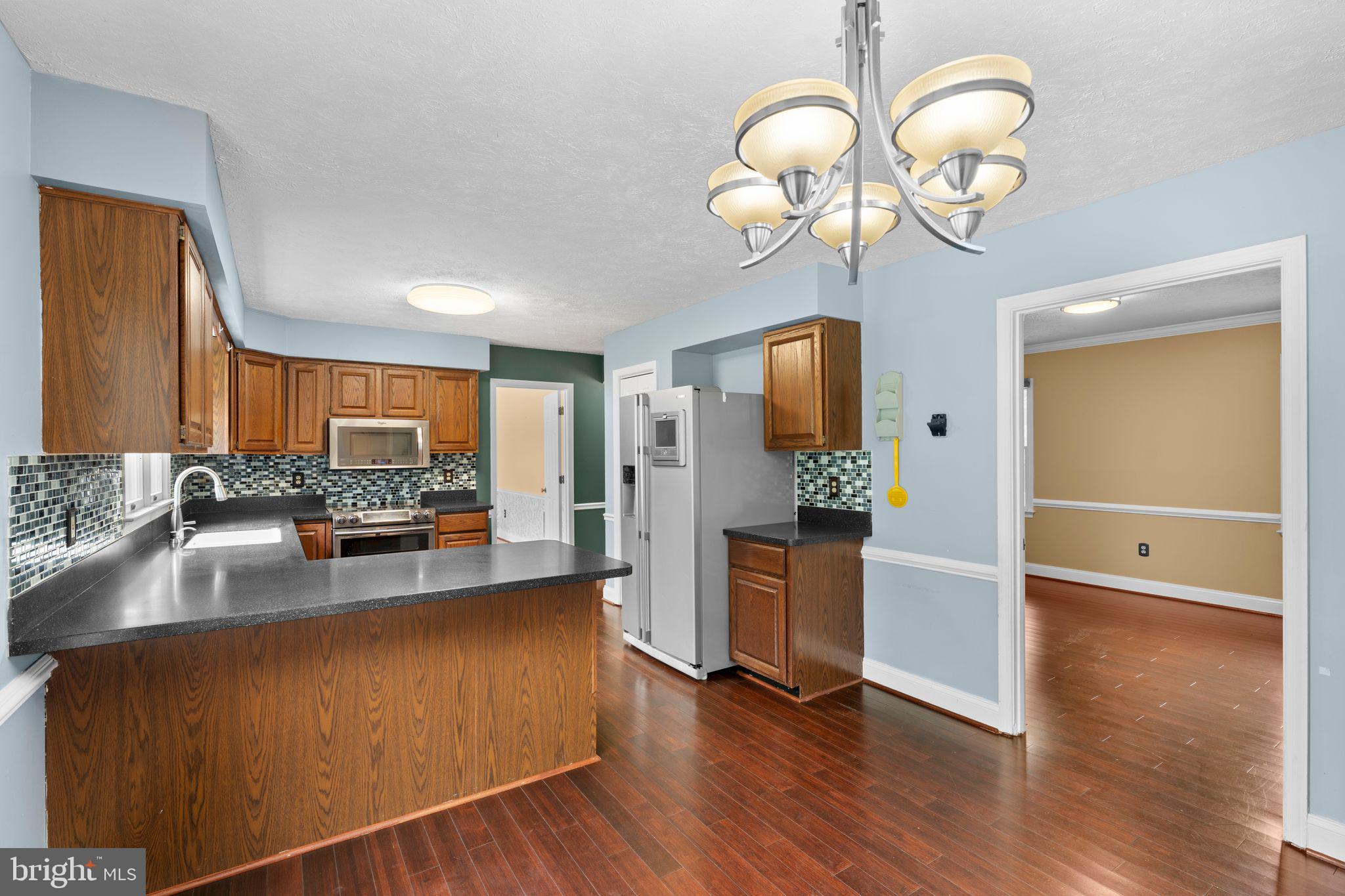 13360 Cameron Court Boston, VA 22713 - Photo 45 of 76 a kitchen with stainless steel appliances granite countertop a sink dishwasher stove and refrigerator with wooden floor