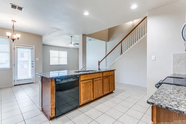 a kitchen with stainless steel appliances granite countertop a stove a sink and a refrigerator