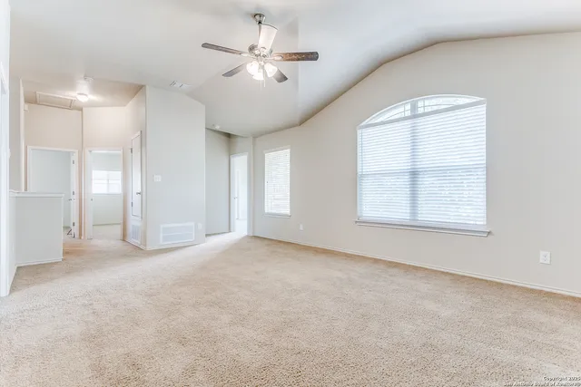 an empty room with windows and fan