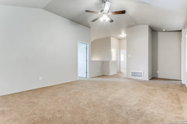 an empty room with fan and windows