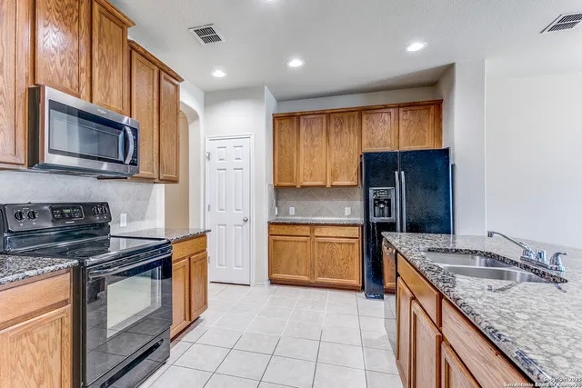 a kitchen with stainless steel appliances granite countertop a stove top oven a sink and dishwasher