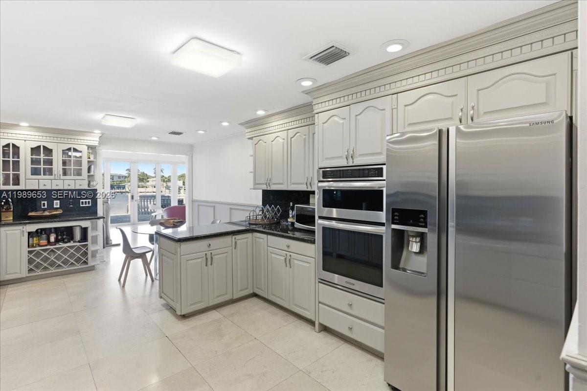 1249 Biscaya Drive Surfside, FL 33154 - Photo 22 of 88 a kitchen with stainless steel appliances and white cabinets