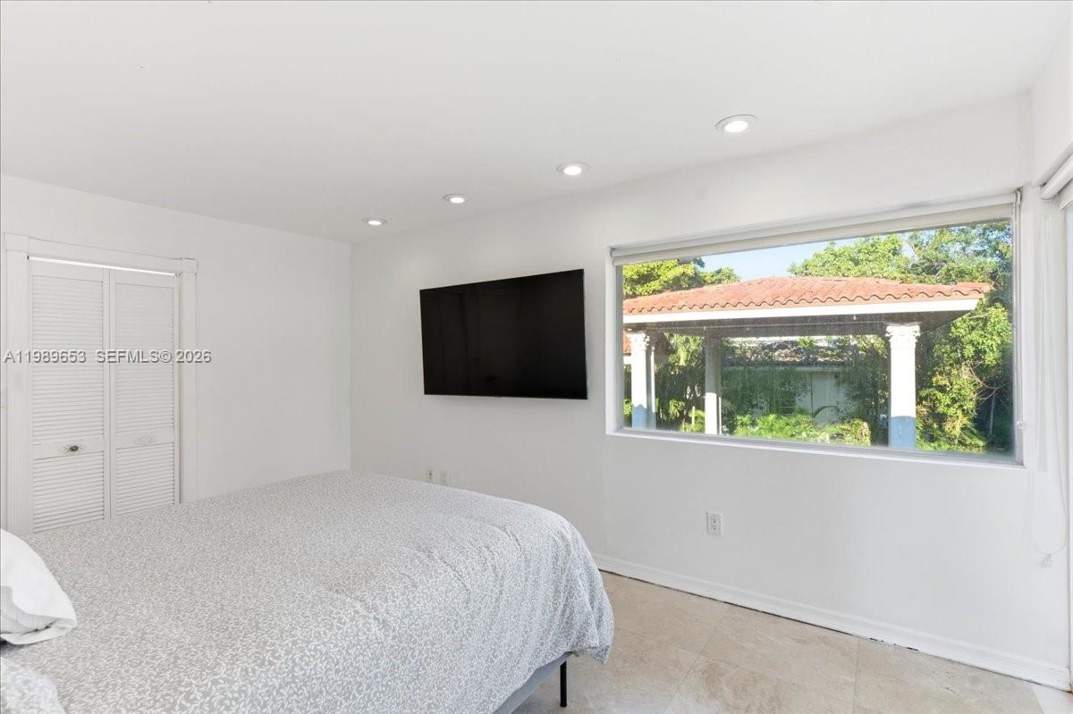 1249 Biscaya Drive Surfside, FL 33154 - Photo 42 of 88 a bedroom with a bed and a flat screen tv