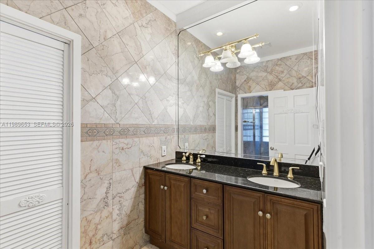 1249 Biscaya Drive Surfside, FL 33154 - Photo 46 of 88 a bathroom with a double vanity sink and a mirror