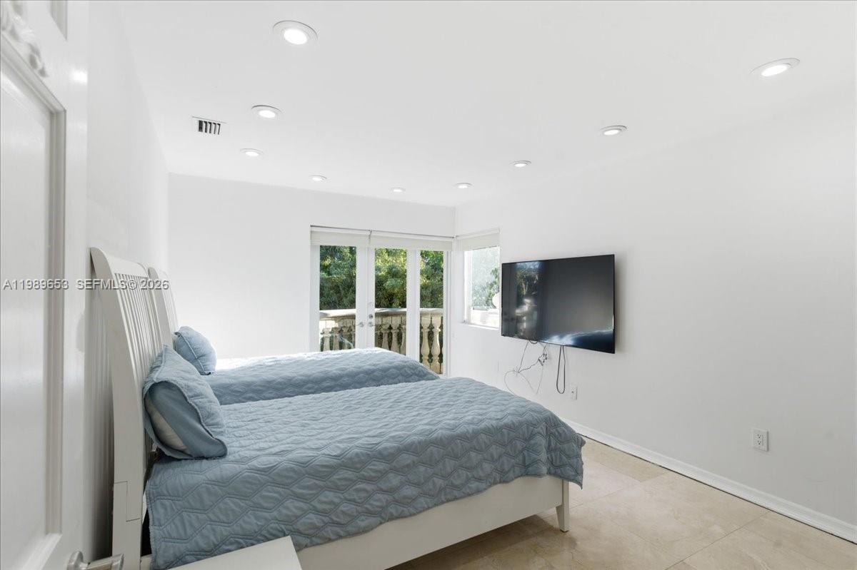 1249 Biscaya Drive Surfside, FL 33154 - Photo 52 of 88 a bedroom with a bed and a flat screen tv