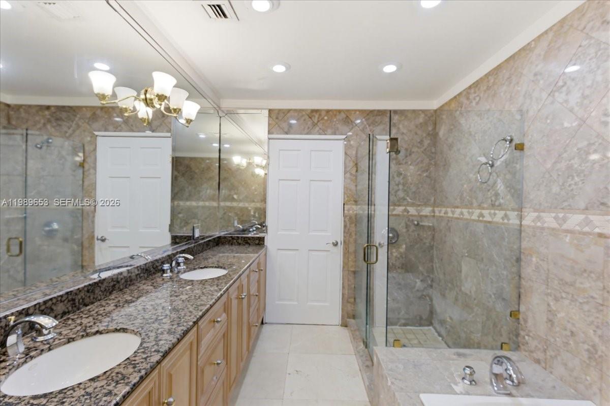 1249 Biscaya Drive Surfside, FL 33154 - Photo 54 of 88 a bathroom with a granite countertop double vanity sink mirror and shower
