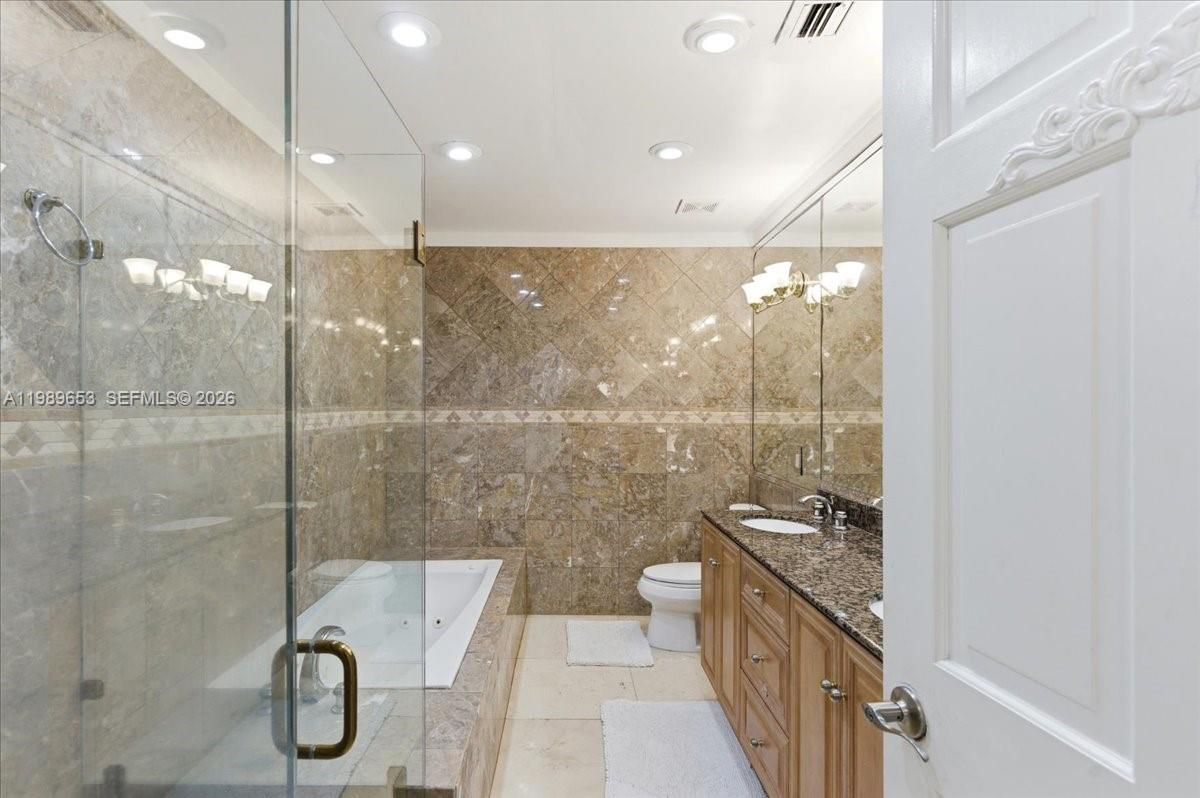 1249 Biscaya Drive Surfside, FL 33154 - Photo 55 of 88 a bathroom with a granite countertop sink a toilet and shower