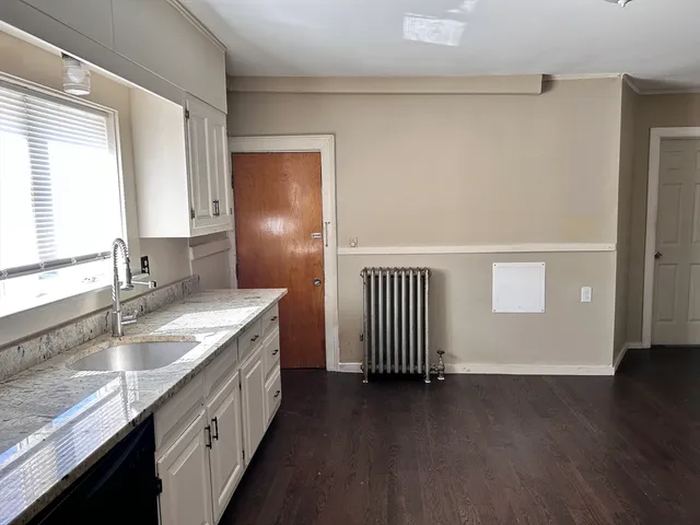 a bathroom with a granite countertop sink and a large mirror
