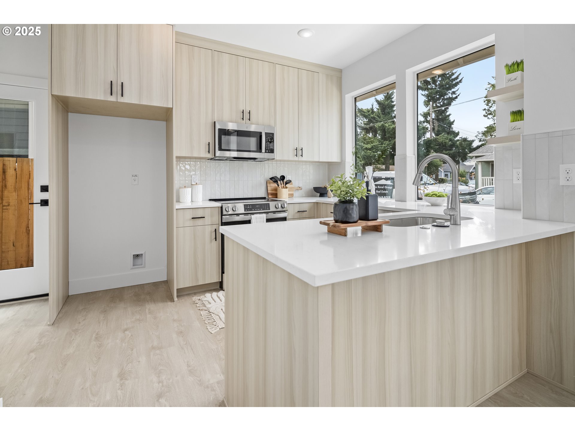 4732 Southeast 65th Avenue Portland, OR 97206 - Photo 5 of 16 a kitchen with stainless steel appliances a sink a stove a refrigerator with white cabinets and wooden floor