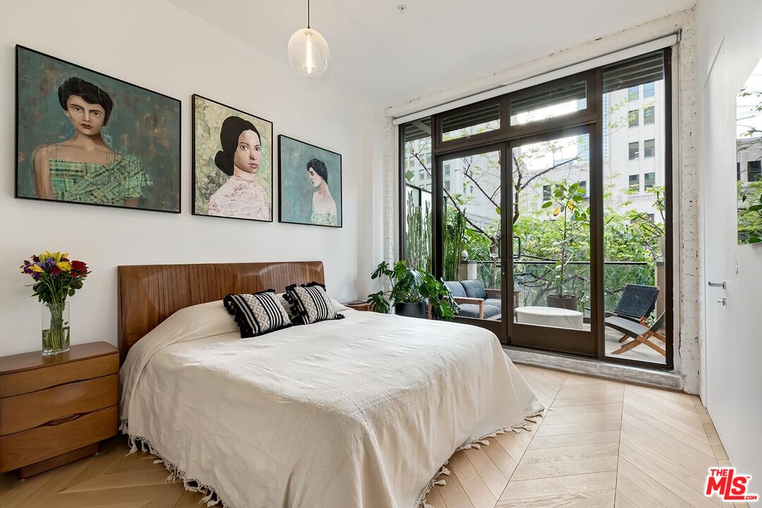 460 South Spring Street, Unit 201 Los Angeles, CA 90013 - Photo 11 of 27 a bed sitting in a bedroom next to a large window