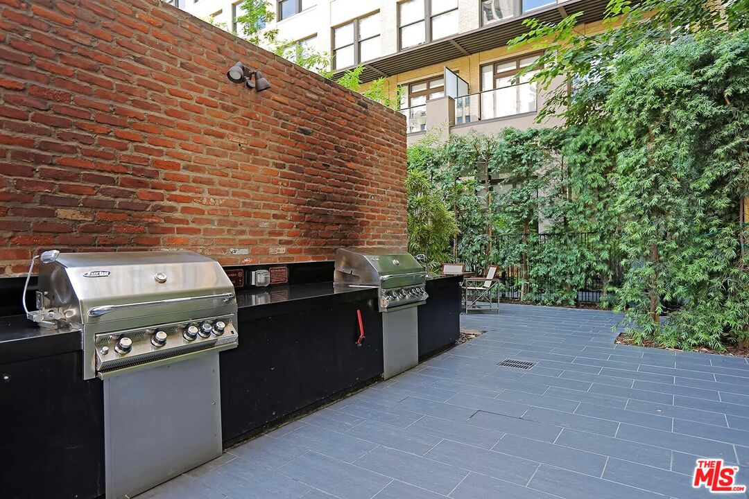 460 South Spring Street, Unit 201 Los Angeles, CA 90013 - Photo 20 of 27 a backyard of a house with stainless steel appliances wooden floor and brick wall