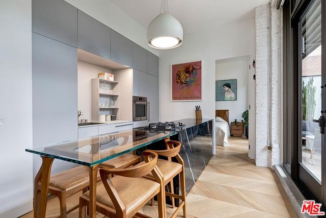 a living room with furniture a large window and wood floor