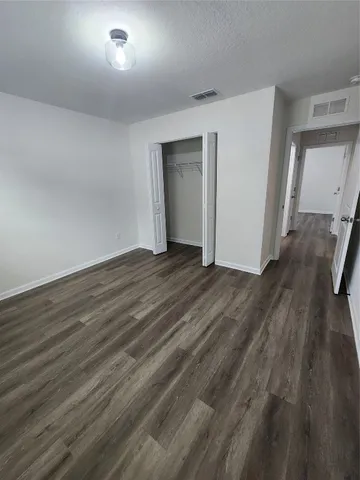 an empty room with wooden floor and closet