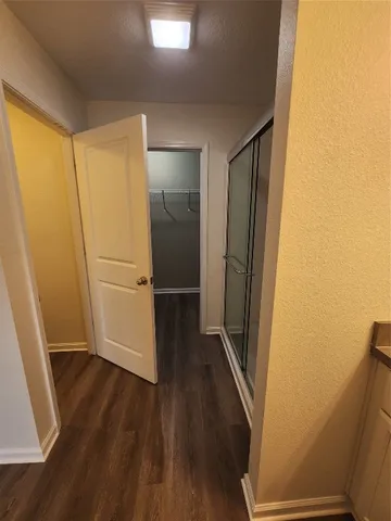 a view of a hallway with wooden floor