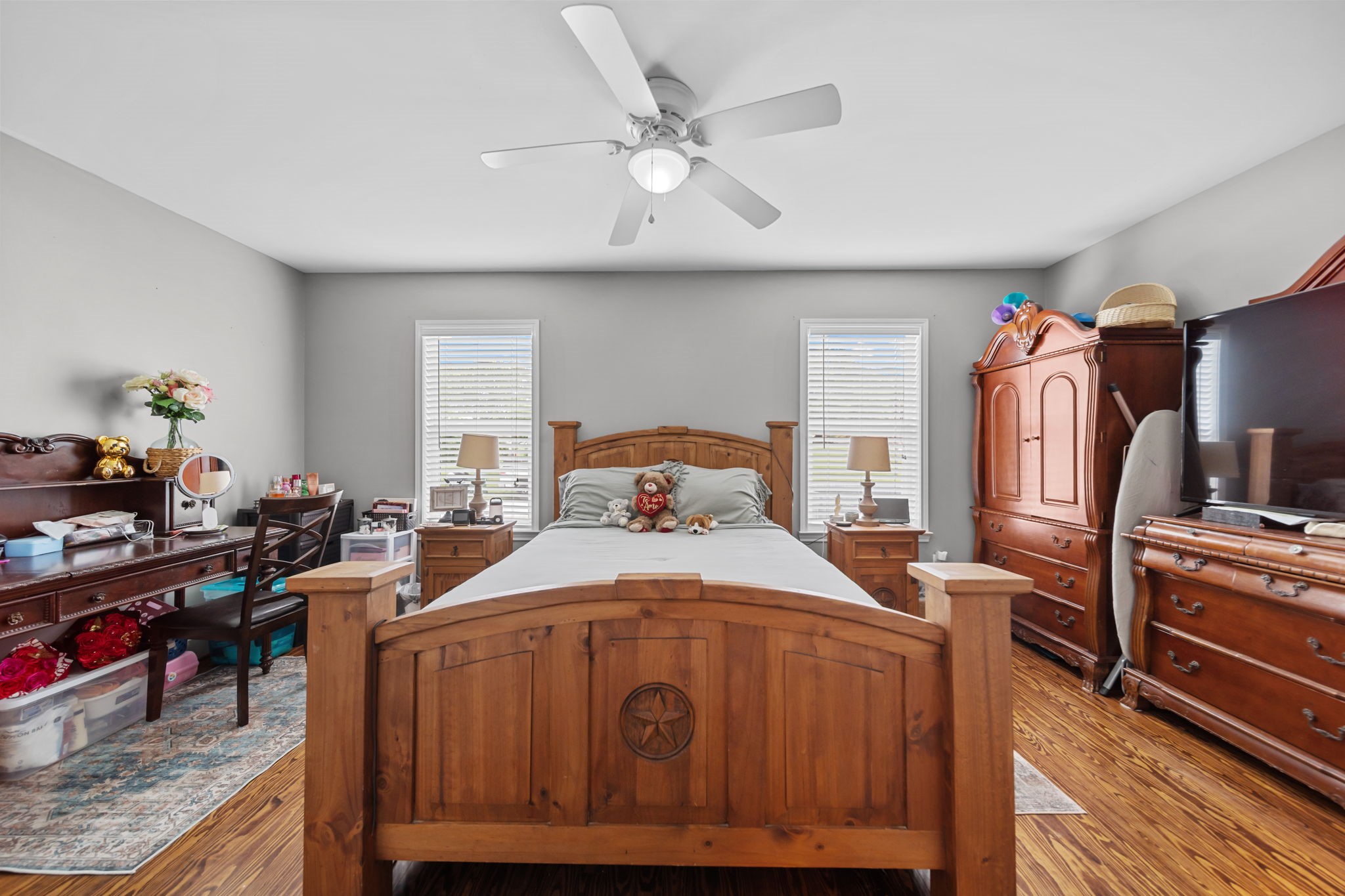 202 Sweed Street Brenham, TX 77833 - Photo 12 of 34 a bedroom with a bed a dresser and potted plants