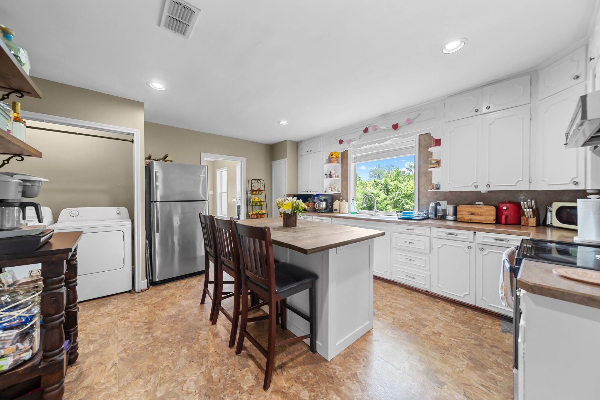 202 Sweed Street Brenham, TX 77833 - Photo 7 of 34 a kitchen with a table chairs refrigerator and microwave