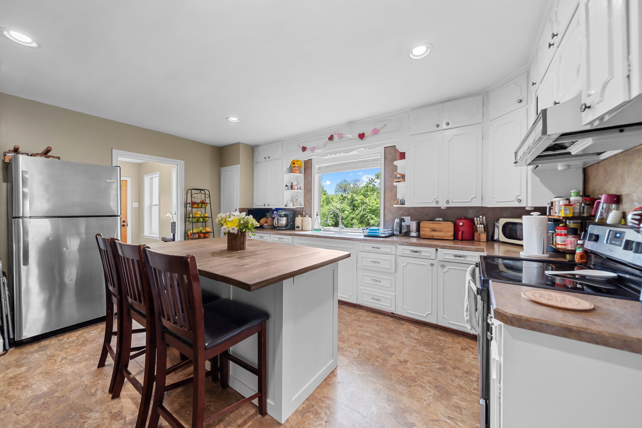 202 Sweed Street Brenham, TX 77833 - Photo 9 of 34 a kitchen with stainless steel appliances granite countertop a white table chairs and a refrigerator