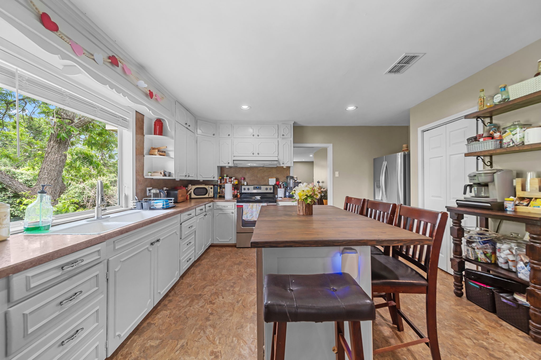 202 Sweed Street Brenham, TX 77833 - Photo 10 of 34 a kitchen with stainless steel appliances granite countertop table chairs sink and cabinets