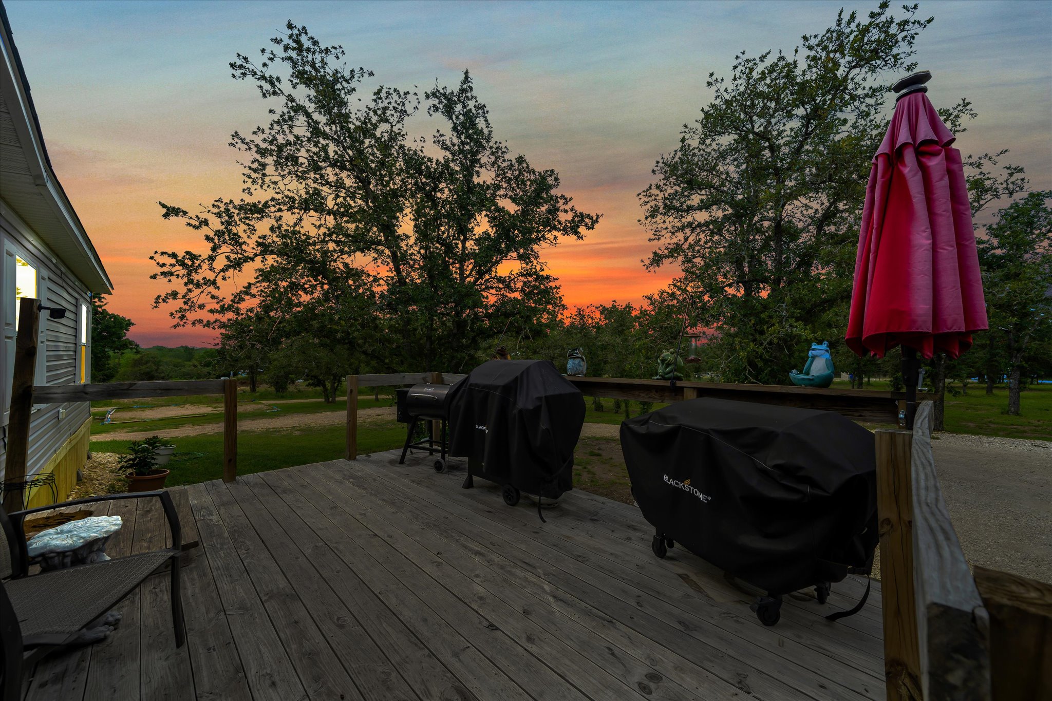 2755 Washburn Road Luling, TX 78648 - Photo 36 of 40 Witness vibrant sunsets from the generous wooden deck, perfect for outdoor dining and entertaining.