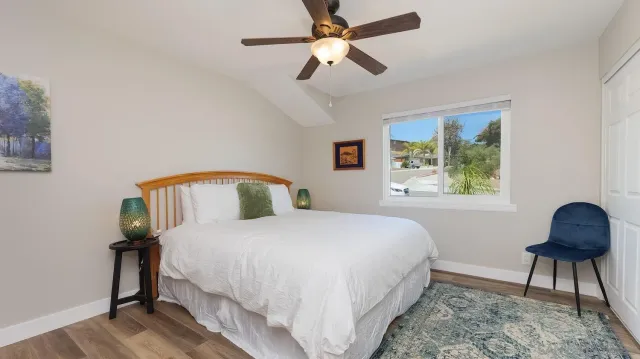 a bedroom with a bed a window and a chandelier