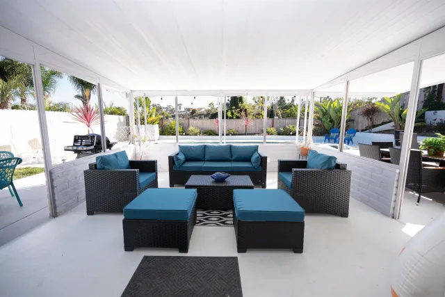 a living room with furniture a flat screen tv and a floor to ceiling window
