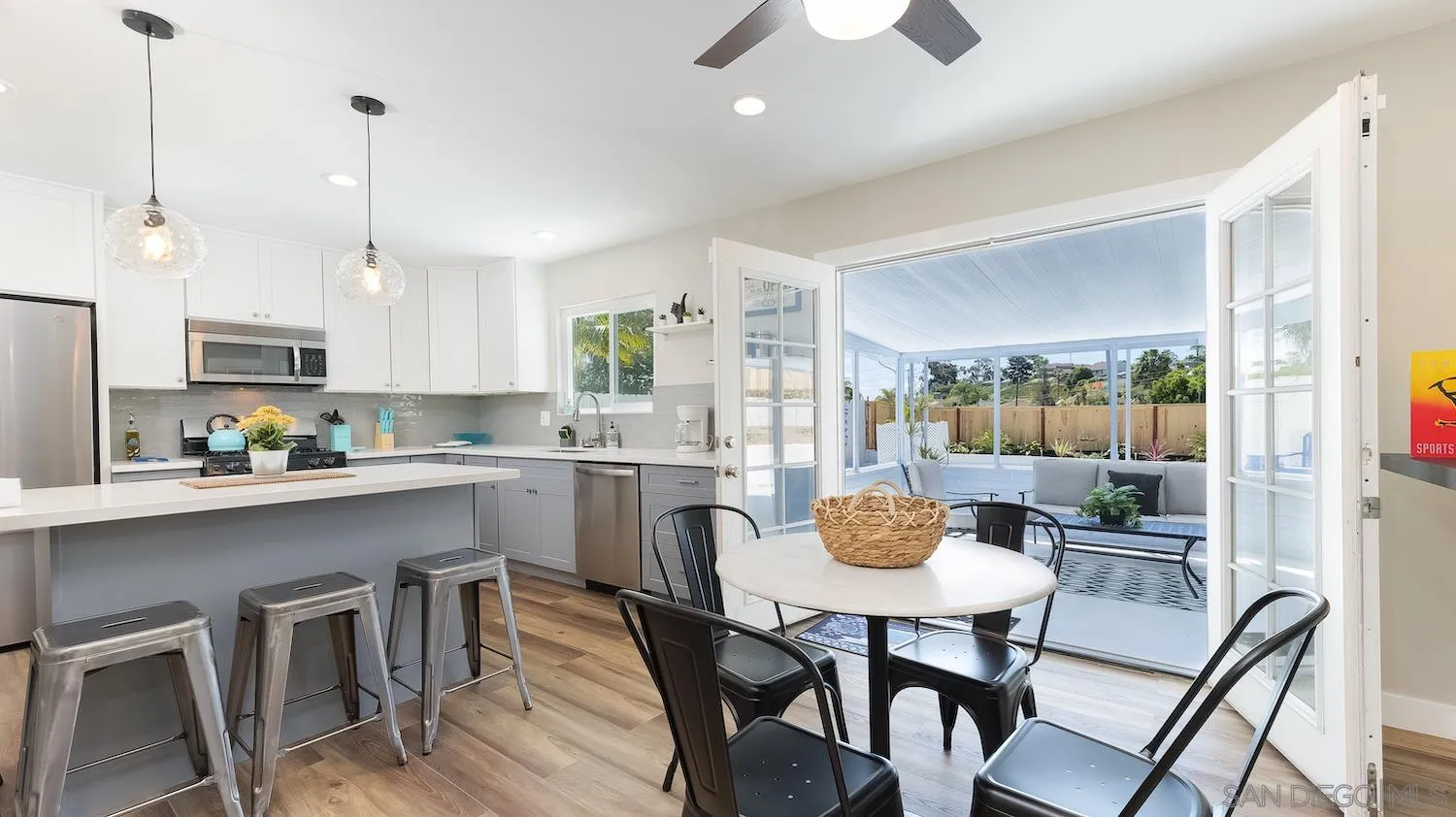 Undisclosed Address Oceanside, CA 92054 - Photo 4 of 19 a kitchen with stainless steel appliances granite countertop a dining table chairs and white cabinets