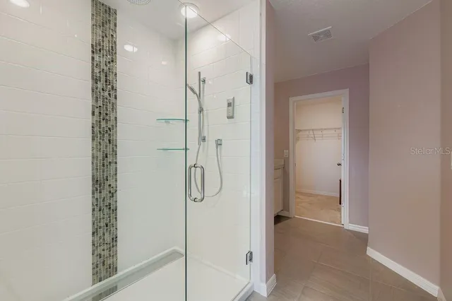 a bathroom with a shower and a glass door