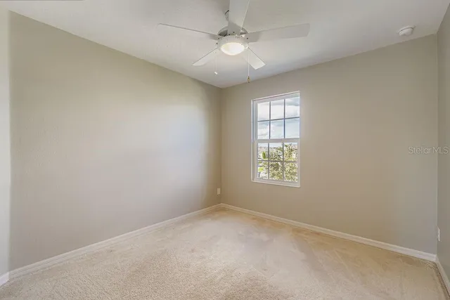 an empty room with a window and a fan