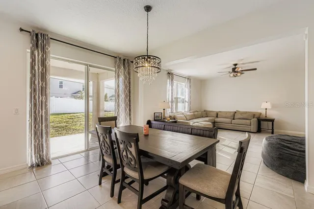 a dining room with furniture a chandelier and wooden floor