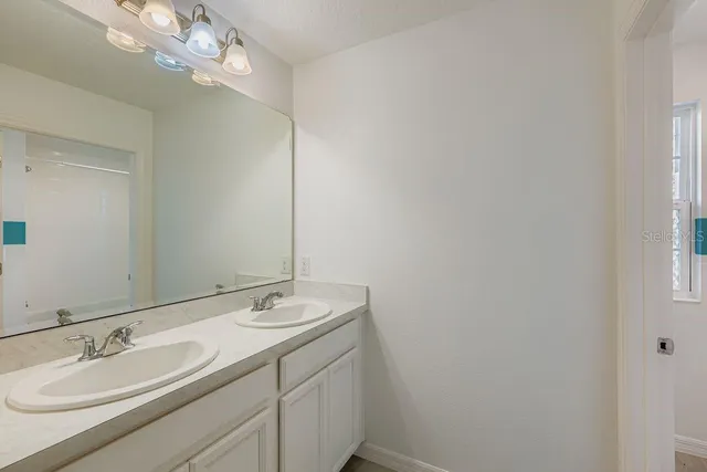 a bathroom with a double vanity sink and a mirror
