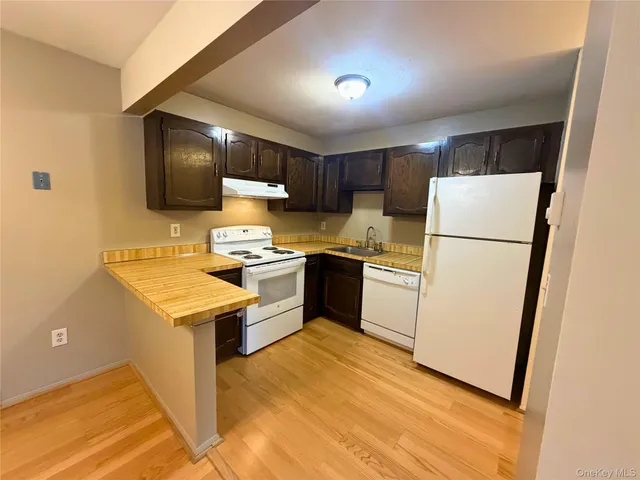 a kitchen with a refrigerator sink and white cabinets