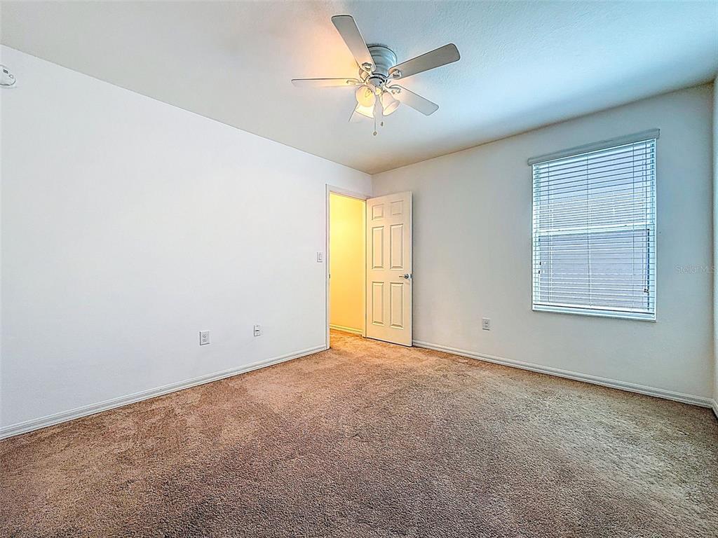 5101 Chipotle Lane Wesley Chapel, FL 33544 - Photo 18 of 25 an empty room with windows and chandelier fan