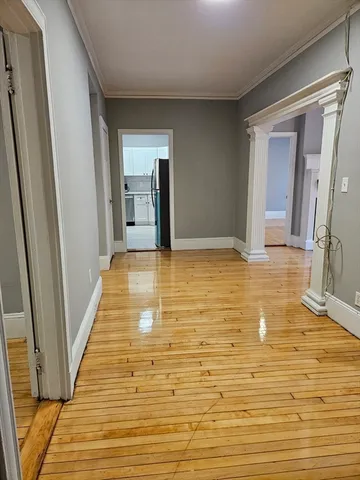 a view of a hallway with wooden floor and staircase