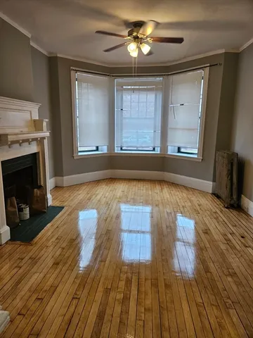 a view of empty room with wooden floor and fireplace
