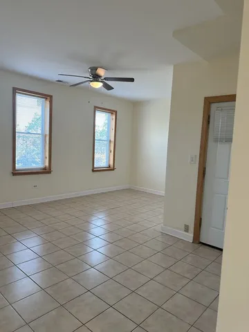 an empty room with windows and fan