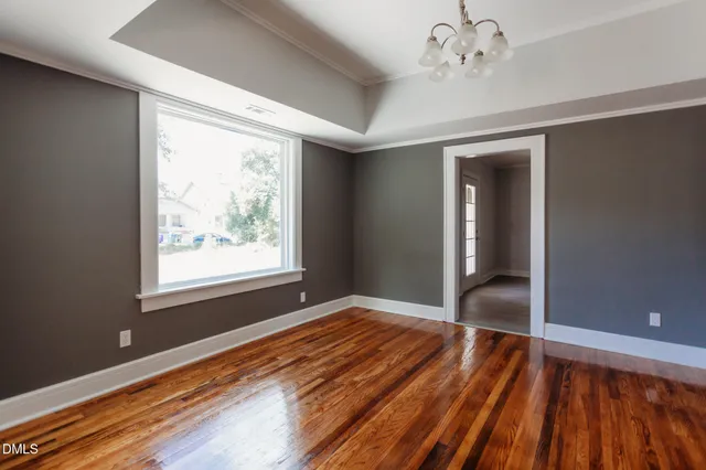 a living room with a fireplace a ceiling fan and wooden floor