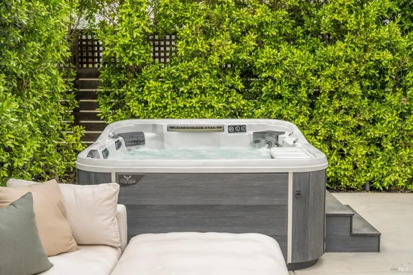 a view of a white house with large windows and a small yard