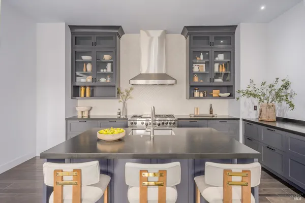 a kitchen with a sink a stove and chairs