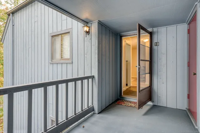 a view of a hallway with wooden floor and closet area