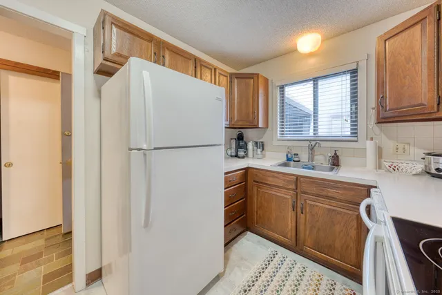 a white refrigerator freezer sitting in a kitchen with stainless steel appliances granite countertop cabinets and a refrigerator
