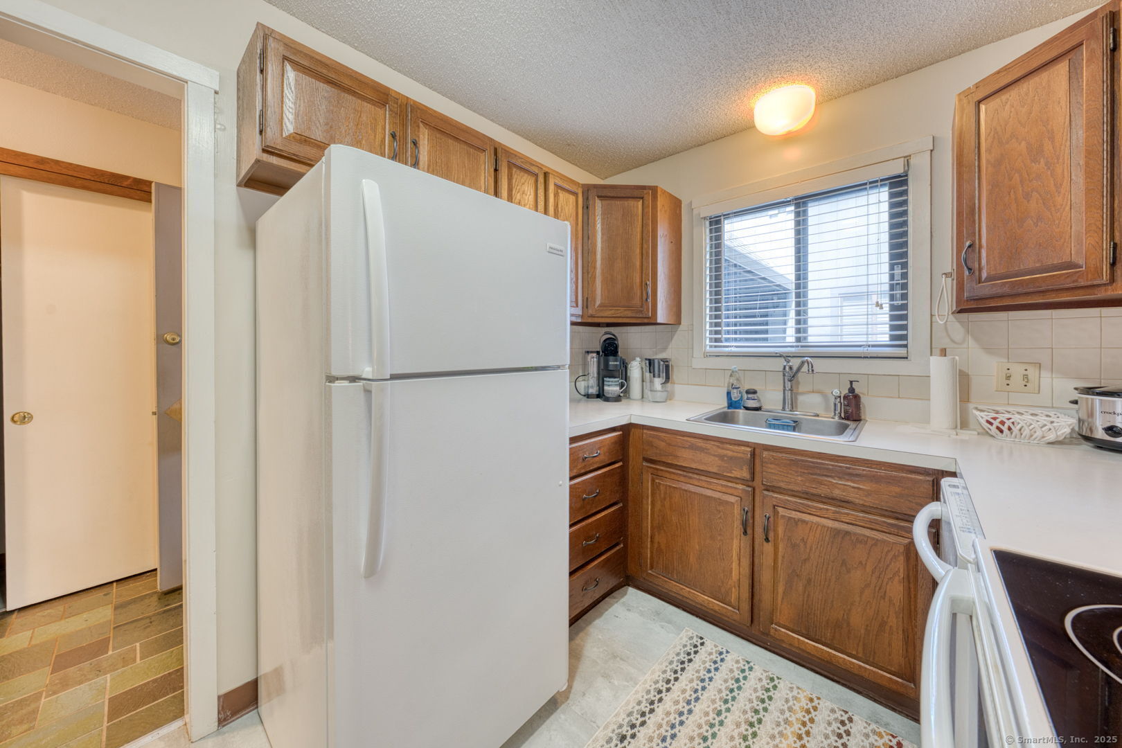 10 Deepwood Drive, Unit 10 Southington, CT 06489 - Photo 5 of 31 a white refrigerator freezer sitting in a kitchen with stainless steel appliances granite countertop cabinets and a refrigerator