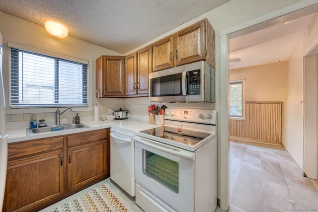 a kitchen with stainless steel appliances a stove sink microwave and cabinets