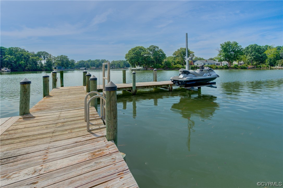 20 South Sioux Road Kilmarnock, VA 22482 - Photo 13 of 46 a view of a lake with wooden stairs and bridge and palm trees