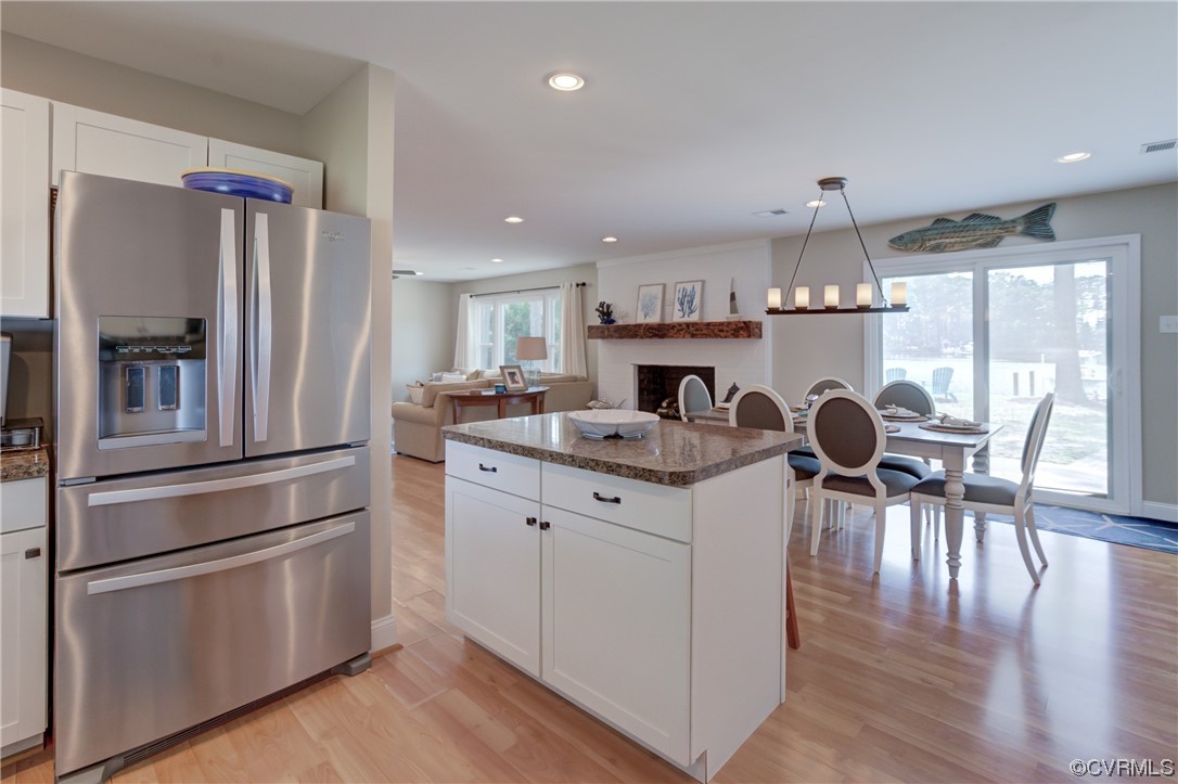 20 South Sioux Road Kilmarnock, VA 22482 - Photo 25 of 46 a kitchen with a refrigerator a stove and a dining table with wooden floor