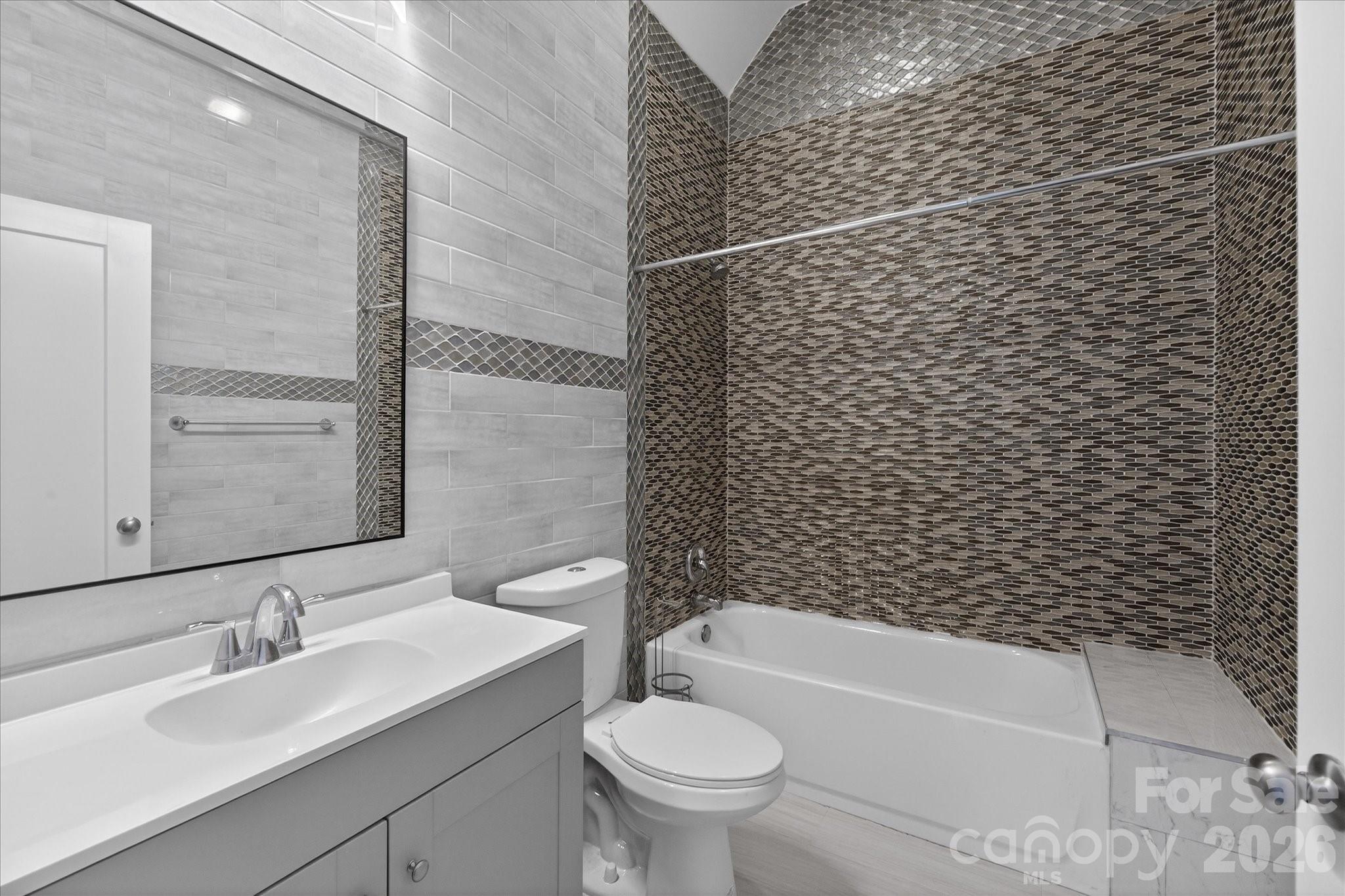 2221 Waxhaw-Marvin Road Waxhaw, NC 28173 - Photo 17 of 30 a bathroom with a granite countertop toilet a sink and a bathtub