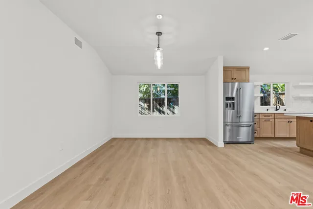 a view of empty room with wooden floor and window