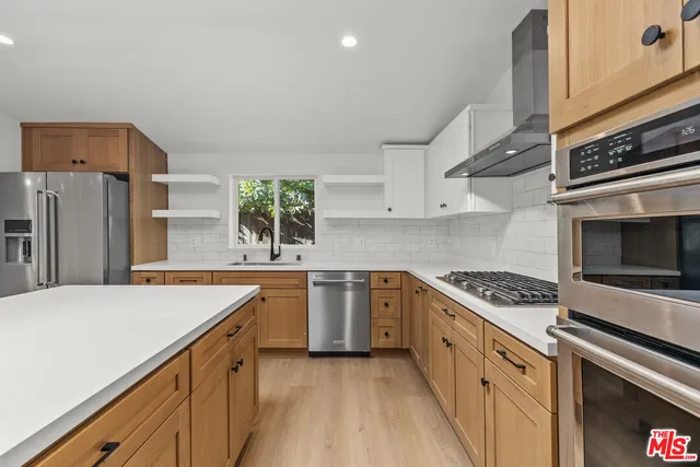 a kitchen with stainless steel appliances a stove microwave and sink
