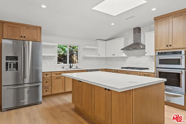 a kitchen with stainless steel appliances white cabinets and a refrigerator