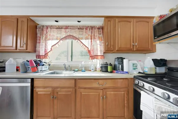 a kitchen with kitchen island granite countertop a sink cabinets and window