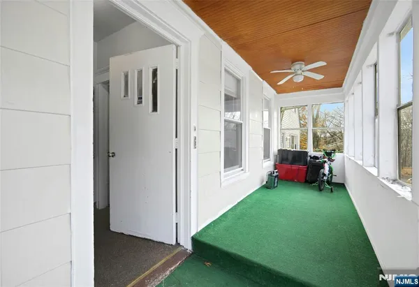 a view of a porch with furniture and floor to ceiling window